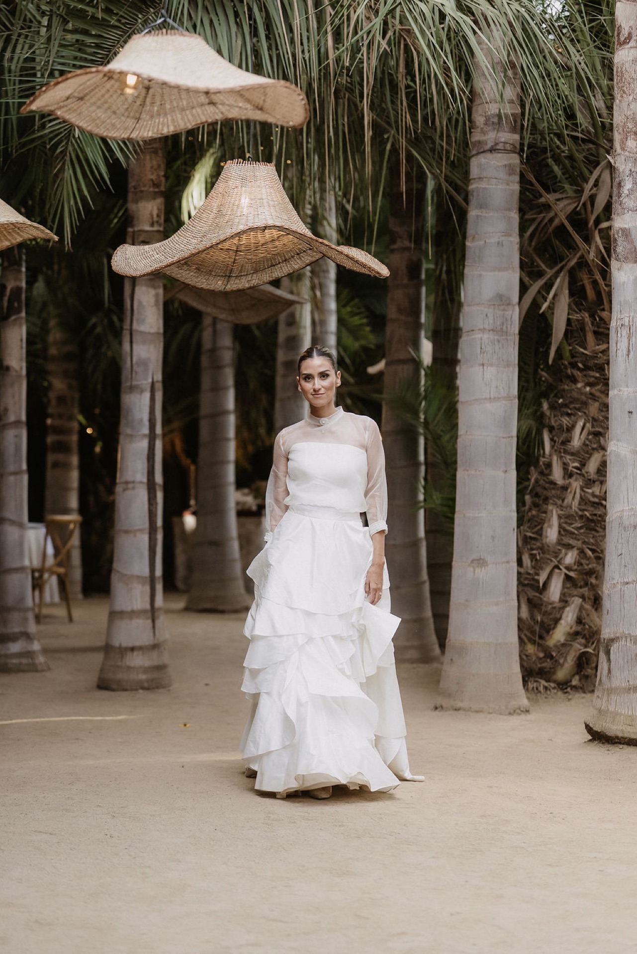 Novia entre palmeras bajo lámparas de raffia, evento Parissimo